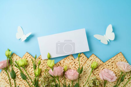 Foto de La tarjeta de felicitación de la Pascua judía se burla con matzá y flores de primavera sobre fondo azul. Vista superior, plano - Imagen libre de derechos