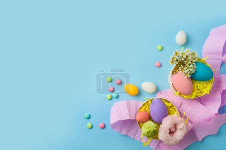 Foto de Concepto de fiesta de Pascua con huevos de Pascua y cajas de regalo sobre fondo azul. Vista superior, plano - Imagen libre de derechos
