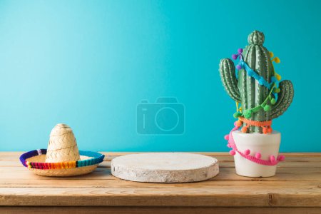 Téléchargez les photos : Podium en bois vide avec cactu et chapeau sombrero sur table en bois sur fond bleu. Cinco de Mayo Célébration des fêtes mexicaines - en image libre de droit