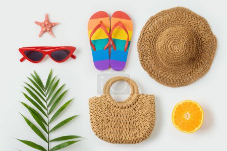 Photo for Tropical summer vacation concept with fashion bag; beach hat, flip flops and plam tree leaf  on white background. Top view from above - Royalty Free Image