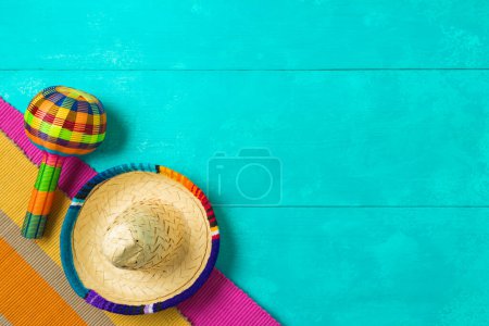 Foto de Decoraciones de fiesta mexicanas con sombrero sombrero y maracas sobre fondo de madera azul. Celebración del Cinco de Mayo. Vista superior desde arriba - Imagen libre de derechos