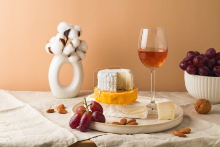 Téléchargez les photos : Nature morte avec fromage, raisins, noix et verre de vin sur la table - en image libre de droit