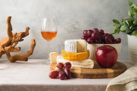 Photo for Still life composition with cheese, grapes, nuts and wine glass on table - Royalty Free Image