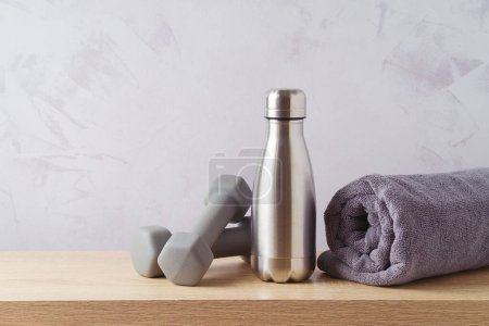 Photo for Summer fitness background with bottle of water, towel  and dumbbells on wooden table - Royalty Free Image