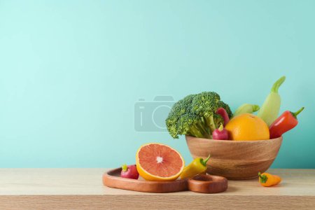 Foto de Dieta de verano concepto de estilo de vida saludable. Hortalizas y frutas crudas sobre mesa de madera sobre fondo azul - Imagen libre de derechos