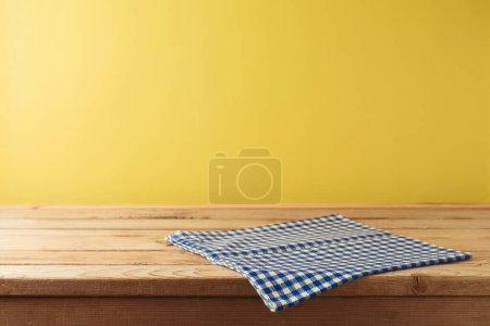 Festa Junina brésilienne concept de festival de récolte d'été. Table en bois vide avec nappe sur fond jaune. Maquette pour la conception et l'affichage du produit