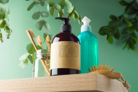 Téléchargez les photos : Flacon de cosmétiques naturels avec étiquettes et brosse à dents en bambou sur étagère en bois sur fond de feuilles vertes. Modèle de maquette d'emballage pour la conception - en image libre de droit