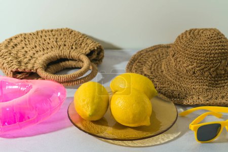 Foto de Fondo creativo moderno de verano con limones en plato colorido y accesorios de playa. Picnic, piscina o playa concepto de fiesta - Imagen libre de derechos