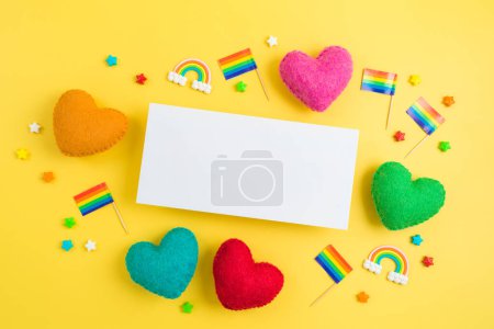 Foto de Fondo del mes del orgullo LGBTQ con tarjeta de felicitación, bandera del arco iris y formas del corazón. Vista superior, plano - Imagen libre de derechos