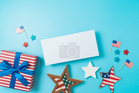 Foto de Feliz Día de la Independencia, concepto de celebración del 4 de julio con maqueta de tarjeta de felicitación, estrellas y bandera de Estados Unidos sobre fondo azul. Vista superior, plano - Imagen libre de derechos
