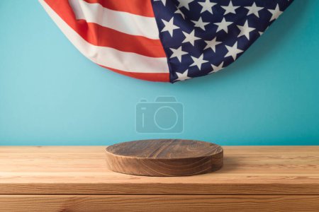 Téléchargez les photos : Grille de podium en bois vide sur la table sur fond drapeau des États-Unis. Modèle de fête nationale américaine pour le design et l'affichage des produits - en image libre de droit