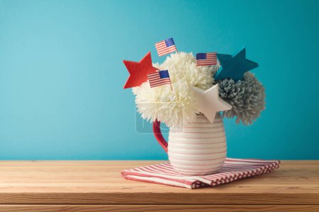 Foto de Feliz Día de la Independencia, concepto de celebración del 4 de julio con decoración de flores y banderas de EE.UU. sobre mesa de madera sobre fondo azul - Imagen libre de derechos