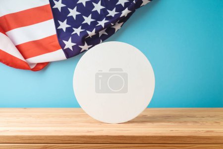 Foto de Cartel blanco redondo en blanco sobre tabla de madera sobre fondo de bandera de Estados Unidos. Burla nacional estadounidense de vacaciones para el diseño y la exhibición de productos - Imagen libre de derechos