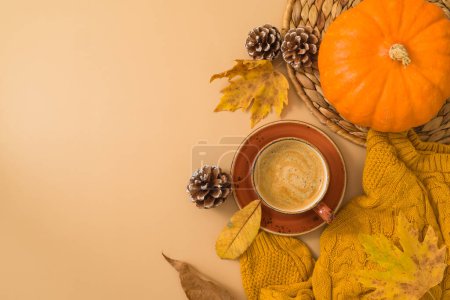Téléchargez les photos : Concept de saison d'automne avec tasse à café, pull chaud, feuilles d'automne et citrouille sur fond beige. Vue de dessus, plan plat - en image libre de droit