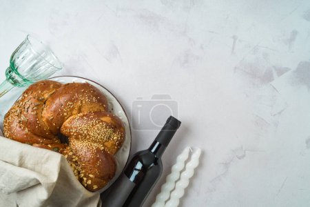 Photo for Shabbat concept with challah bread, wine and candles on bright background. Top view, flat lay - Royalty Free Image