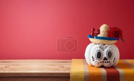 Téléchargez les photos : Jour des morts, concept de vacances Dia De Los Muertos. Crâne de sucre Halloween citrouille et chapeau de fête mexicain sur table en bois sur fond rose - en image libre de droit