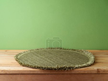 Téléchargez les photos : Table en bois vide avec tapis de place sur fond mural vert. Modèle de Noël pour la conception et l'affichage des produits. - en image libre de droit