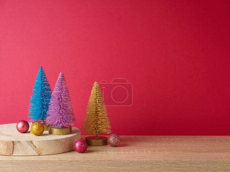 Téléchargez les photos : Table en bois moderne avec décoration colorée en pin sur fond rose. Modèle de Noël pour la conception et l'affichage des produits - en image libre de droit
