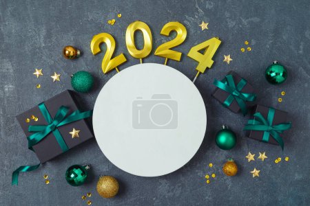 Photo for Christmas holiday concept with 2024 new year, decorations, gift boxes and ornaments on dark background. Top view, flat lay - Royalty Free Image