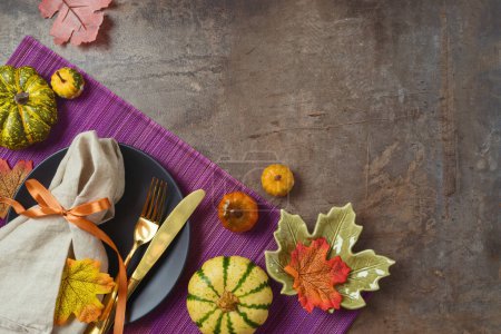 Téléchargez les photos : Thanksgiving concept de fête avec assiette, citrouille et feuilles d'automne sur fond sombre. Vue de dessus, plan plat - en image libre de droit
