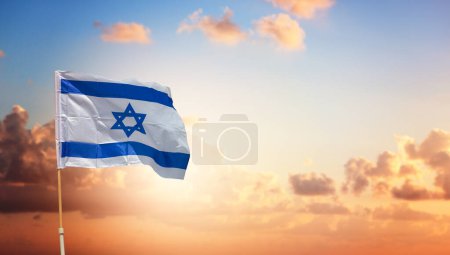 Foto de Bandera de Israel con una estrella de David sobre hermoso fondo del cielo al atardecer - Imagen libre de derechos