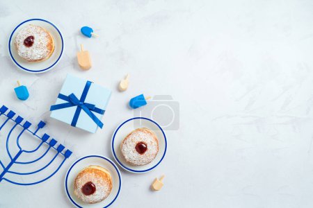 Photo for Jewish holiday Hanukkah background with traditional donuts, menorah and gift box. Top view, flat lay - Royalty Free Image