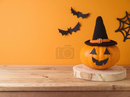 Photo for Halloween jack o lantern pumpkin decoration on wooden table over orange wall background. Holiday mock up for design and product display - Royalty Free Image