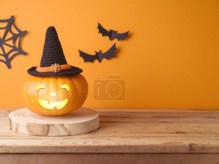Foto de Halloween jack o linterna decoración de calabaza en mesa de madera sobre fondo de pared naranja - Imagen libre de derechos
