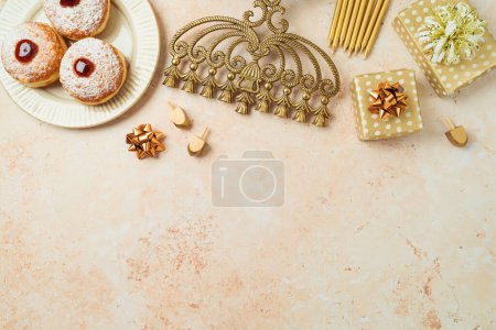 Foto de Fiesta judía concepto de Hanukkah con rosquillas tradicionales, menorah y caja de regalo sobre fondo de piedra. Vista superior, plano - Imagen libre de derechos