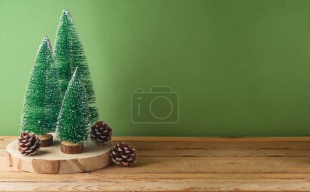 Foto de Mesa de madera con decoración de pino sobre fondo verde. Navidad e invierno se burlan de las vacaciones para el diseño y la exhibición del producto - Imagen libre de derechos