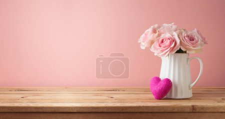 Photo for Romantic rose flower bouquet with heart shape on wooden table over pink background - Royalty Free Image