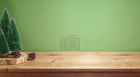 Foto de Mesa de madera vacía con decoración de pino sobre fondo verde. Navidad e invierno se burlan de las vacaciones para el diseño y la exhibición del producto - Imagen libre de derechos