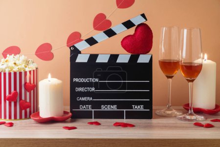 Téléchargez les photos : Happy Valentine's day et concept de film romantique avec film clapper board, formes de coeur, vin et pop-corn sur table en bois sur fond tendance - en image libre de droit