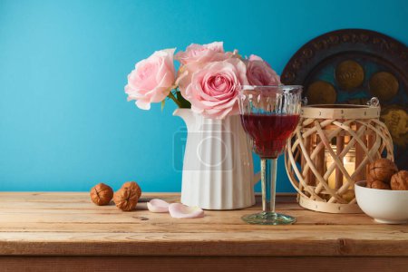 Photo for Jewish holiday Passover concept with wine glass, matzah and flowers on wooden table over blue background. - Royalty Free Image