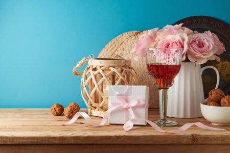 Téléchargez les photos : Noël juif concept de Pâque avec verre à vin, matzah et boîte cadeau sur table en bois sur fond bleu. - en image libre de droit