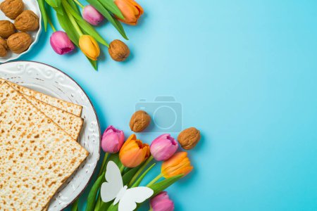 Foto de Concepto de Pascua judía con matzá y flores de tulipán de primavera sobre fondo azul. Vista superior, composición plana - Imagen libre de derechos