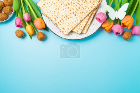Photo for Jewish holiday Passover concept with matzah and  spring tulip flowers on blue  background. Top view, flat lay composition - Royalty Free Image