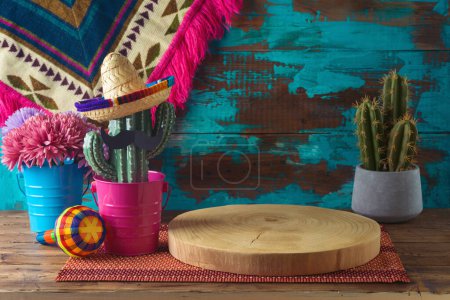 Foto de Tronco de madera vacío en la mesa con decoración de cactus sobre fondo de pared azul. Maqueta de fiesta mexicana para diseño y exhibición de productos - Imagen libre de derechos