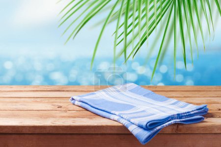 Foto de Mesa de madera vacía con mantel azul sobre fondo bokeh playa tropical. Maqueta de verano para el diseño y la exhibición del producto. - Imagen libre de derechos