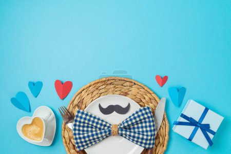 Téléchargez les photos : Table pour le petit déjeuner de la fête des pères avec tasse à café en forme de coeur, assiette et boîte cadeau sur fond bleu. Vue de dessus, plan plat - en image libre de droit