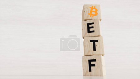 BTC ETF - Exchange Traded Fund (ETF) and Bitcoin cryptodivisa concept. Introduce the concept of digital money background. Wooden vertical cube with bitcoin icon standing with "ETF" text. White background, 3D representation