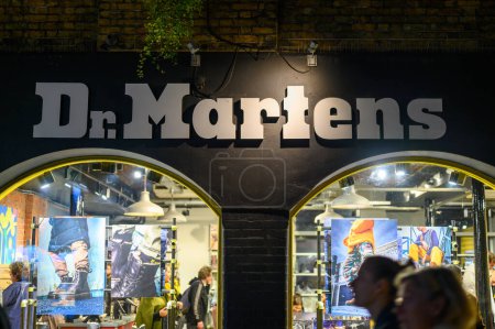 Foto de LONDRES - 12 de noviembre de 2022: La icónica tienda del Dr. Martens en Londres brilla de noche, con su signo iluminado dibujando el ojo. - Imagen libre de derechos