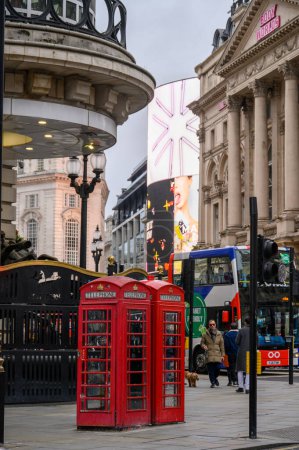 Foto de LONDRES - 13 de noviembre de 2022: Las tradicionales cabinas telefónicas rojas de Piccadilly Circus en Londres son un símbolo del patrimonio británico y una atracción turística popular. - Imagen libre de derechos
