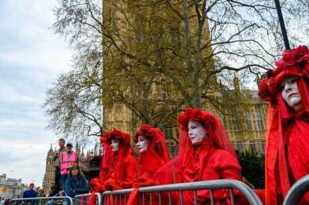 Photo for LONDON - April 22, 2023: The Red Brigade silently protests outside the House of Parliament, making their statement during the Extinction Rebellion march in London. - Royalty Free Image