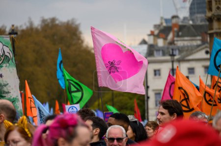 Foto de LONDRES - 22 de abril de 2023: Las banderas de protesta ambiental se elevan por encima de los manifestantes de XR en Londres, una poderosa muestra de activismo y defensa del clima. - Imagen libre de derechos