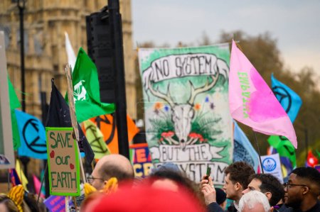 Foto de LONDRES - 22 de abril de 2023: Experimente el simbolismo mientras las banderas de protesta ambiental ondean sobre los manifestantes de XR en un rotundo llamado a la acción climática. - Imagen libre de derechos