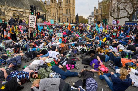 Foto de LONDRES - 22 de abril de 2023: Descubra la emotiva protesta de muerte de XR mientras los activistas se acuestan ante el Parlamento, transmitiendo un mensaje solemne sobre la crisis climática y la urgencia por el cambio. - Imagen libre de derechos