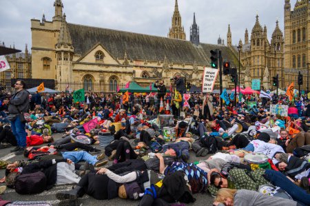 Foto de LONDRES - 22 de abril de 2023: Descubra la emotiva protesta de muerte de XR, activistas que yacen ante el Parlamento, haciéndose eco de la urgencia climática. - Imagen libre de derechos