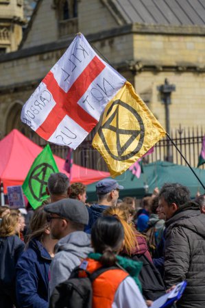Foto de LONDRES - 22 de abril de 2023: Un himno visual para el cambio: Banderas XR bailan sobre la marcha de protesta de Londres, encarnando la dedicación del movimiento a la acción climática. - Imagen libre de derechos