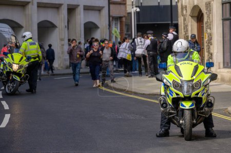 Photo for LONDON - April 22, 2023: Police motorcycles maintain order at the Extinction Rebellion protest march in London, ensuring a safe environment for climate activists. - Royalty Free Image